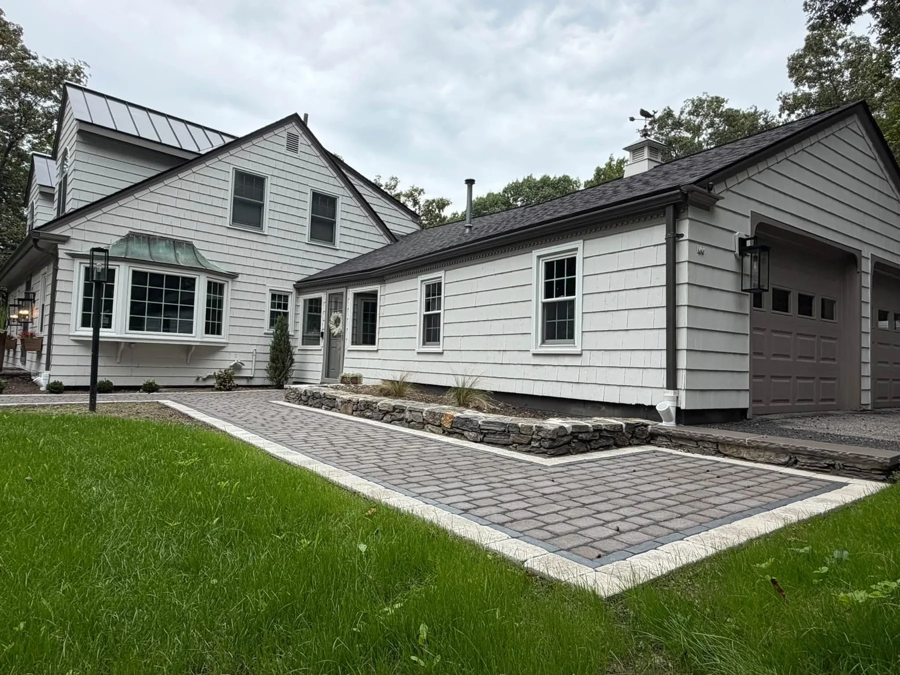 Completed gray paver walkway and stone edging at a Shrewsbury home