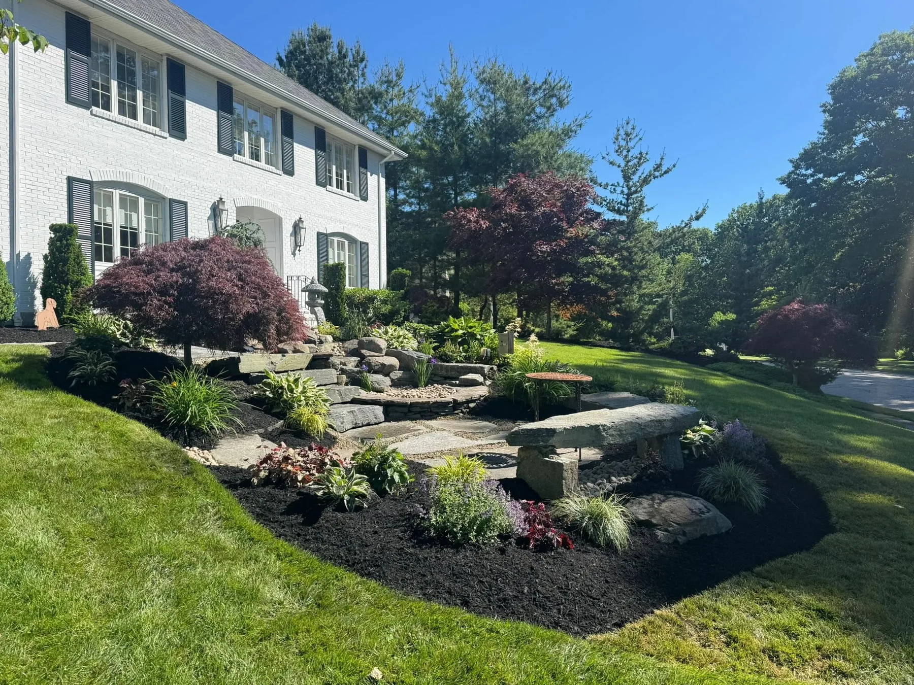 Natural stone landscape features amid established garden beds